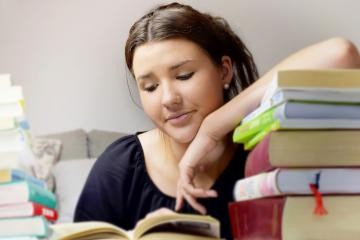 Lesende Jugendliche mit Bücherstapel