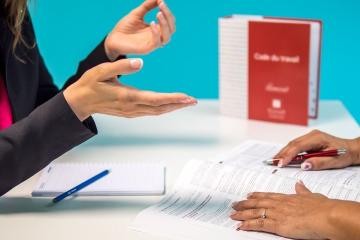 Symbolbild einer Beratung zu einer Verwaltungsangelegenheit mit Formularen und Gesetzestexten