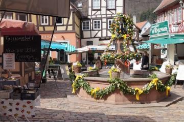 Der Wochenmarkt platziert seine Marktstände rund um den österlich geschmückten Brunnen