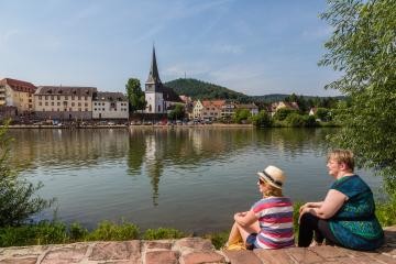 Zwei Frauen schauen am Kleingemünder Ufer auf die Altstadt und den Neckar