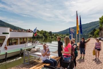 Touristen am Neckarlauer schauen einem anlegenden Schiff zu