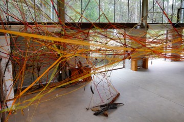 Installation mit gespannten Bändern in großer Halle