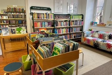 Blick in die Jugendbücherei mit Bücherregalen und Sofa