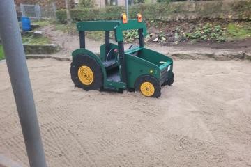 grüner Spieltraktor im Außengelände der Kita